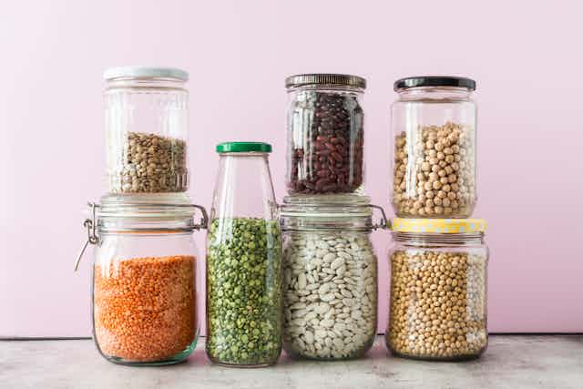 Assorted legumes stored in jam and mason jars.