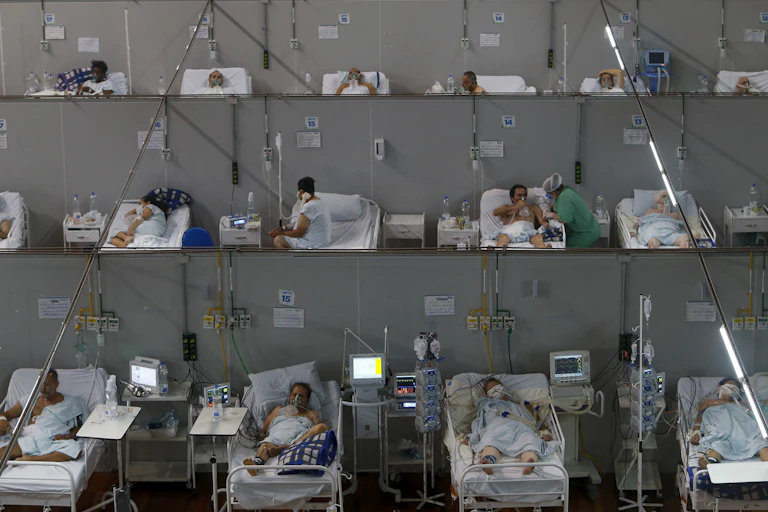 Low aerial shot of bed after bed with COVID-19 patients in them, some on respirators