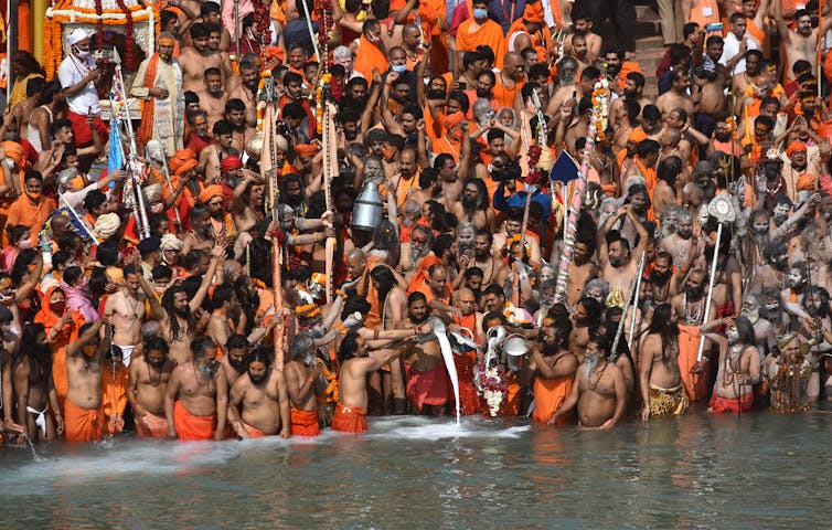 Indian holy men and other pilgrims take the holy dip in the Ganges River during the Kumbh Mela at Haridwar, Uttarakhand, India, April 14 2021.