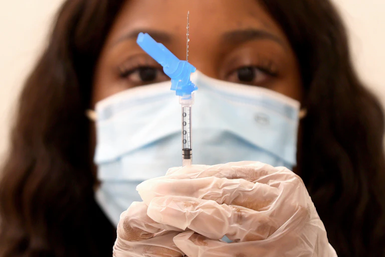 A nurse prepares a J&J shot.