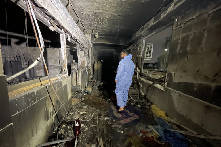 A man walks through a burned out hospital in Iraq.