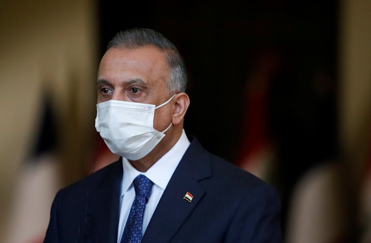Iraqi Prime Minister Mustafa al-Kadhemi is seen wearing a face mask.