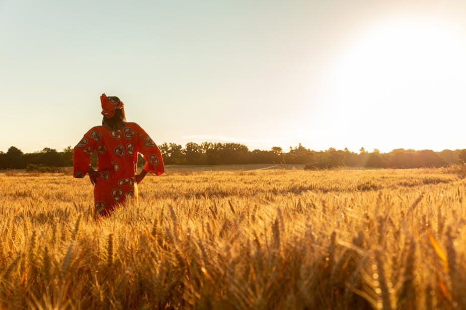 A woman stands in a field of crops