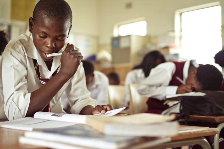 Closeup image of a young boy studying in a classroom.