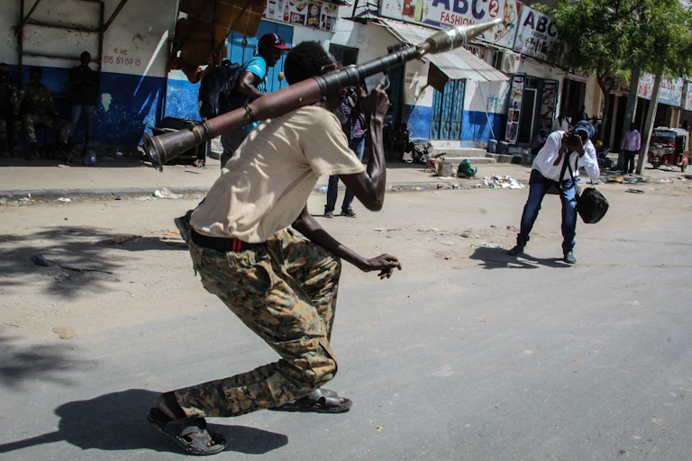 Man wearing army fatigues and holding a weapon