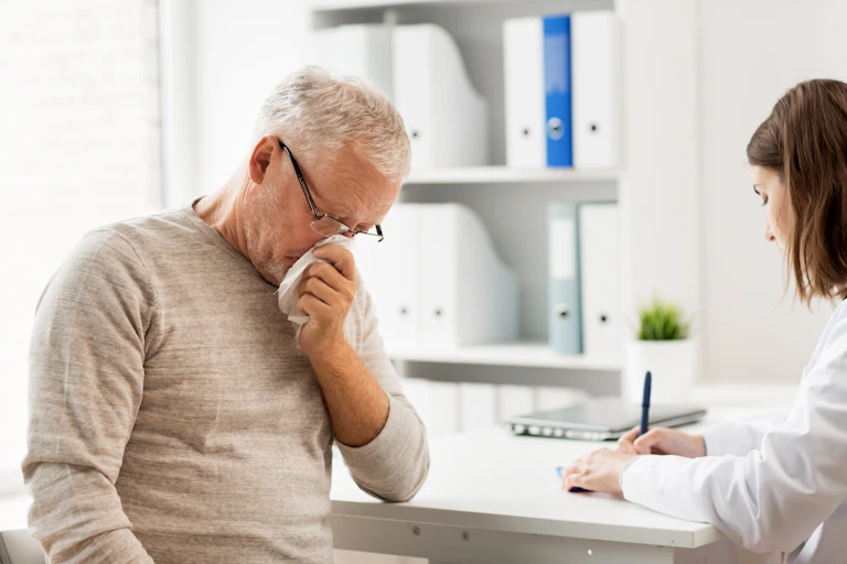 Un hombre mayor con problemas respiratorios en una consulta médica.