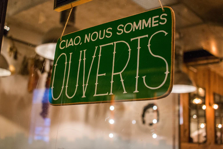 A store sign in French that reads 'Hello, we are open'