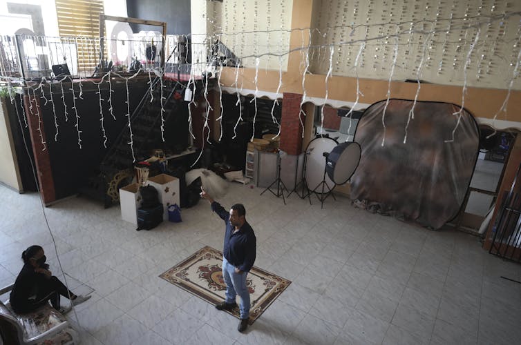 A man stands in an empty ballroom.