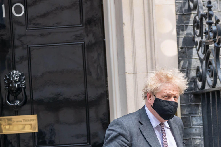 Boris Johnson leaving Downing Street wearing a face mask.