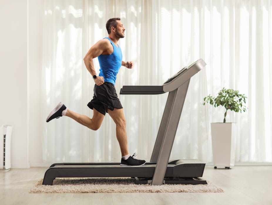 Man running on a treadmill indoors.