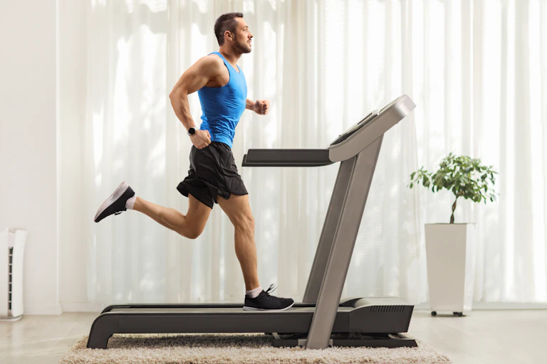 Man running on a treadmill indoors.