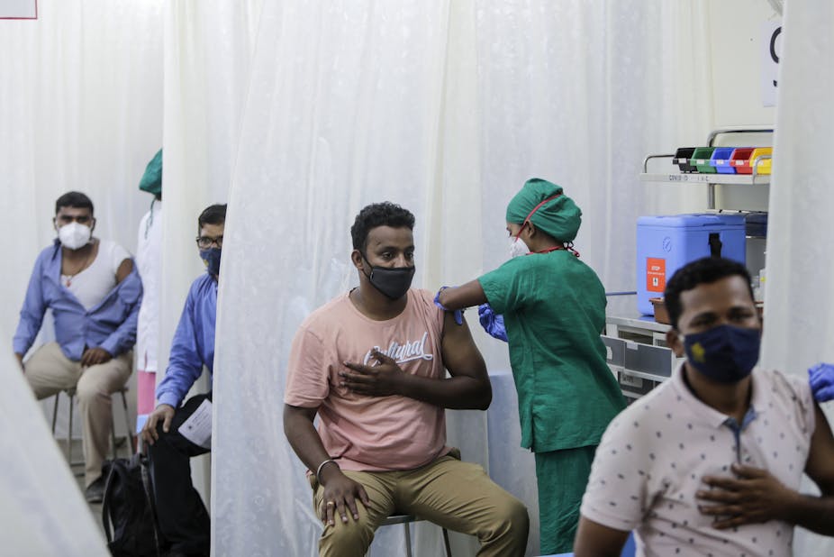 Men in a tent being vaccinated. 