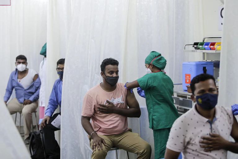Men in a tent being vaccinated.