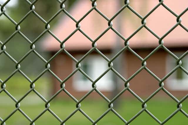 Blurred building through chainlink fence