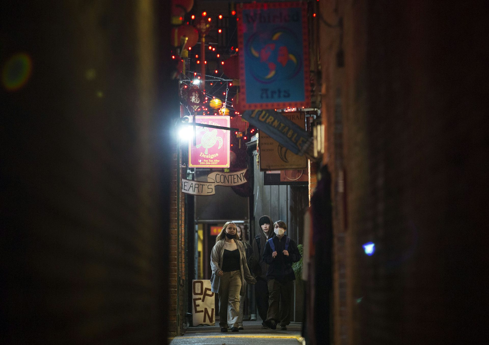 Teens walk in an alley.