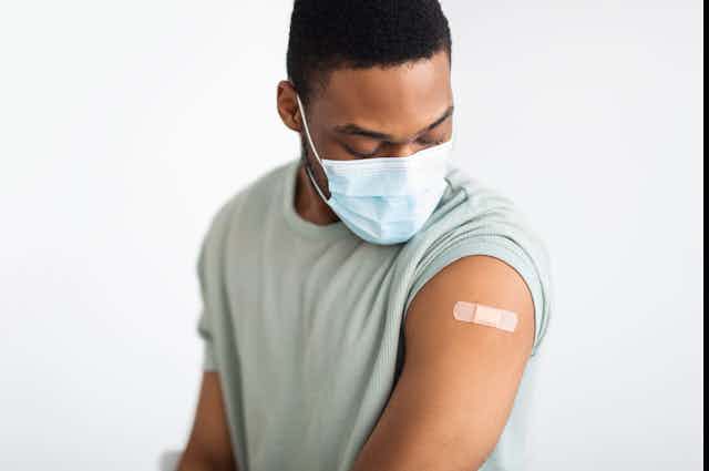 homme regardant son bras après avoir reçu un vaccin
