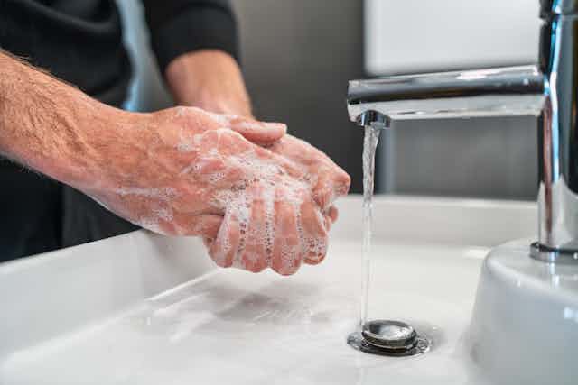 A man washes his hands with soap.