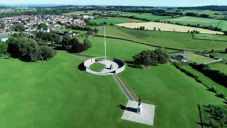 Aerial view of the site of the Battle of Bannockburn, featuring a monuments and green fields.