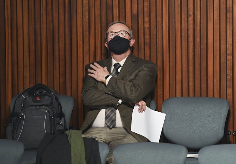 David Williams looks up at the ceiling while wearing a mask.