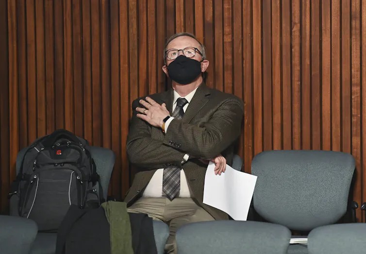 David Williams looks up at the ceiling while wearing a mask.