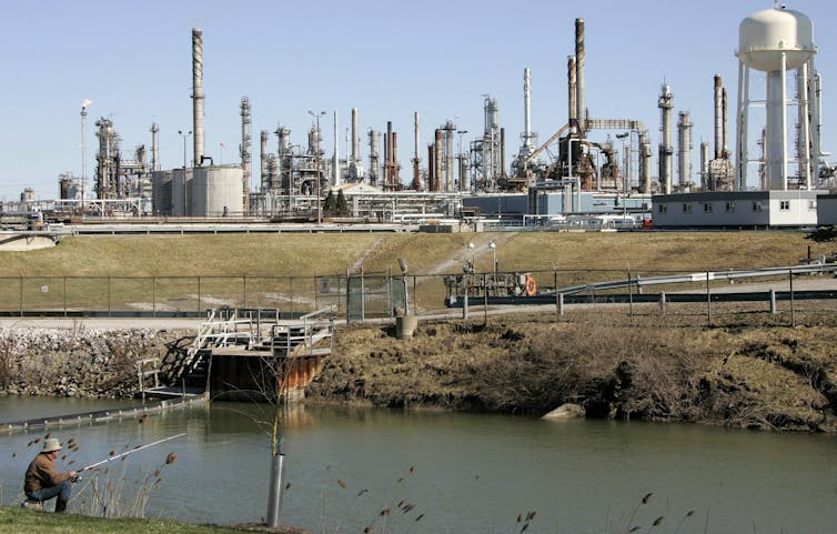 A man fishes next to a refinery south of Sarnia, Ont.
