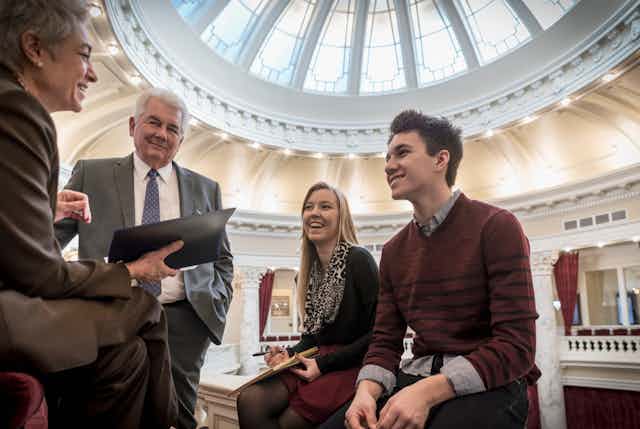 Two interns talk to two politicians in Capitol Hill.