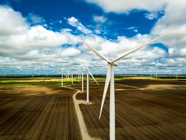 Wind turbines sit on a farm.