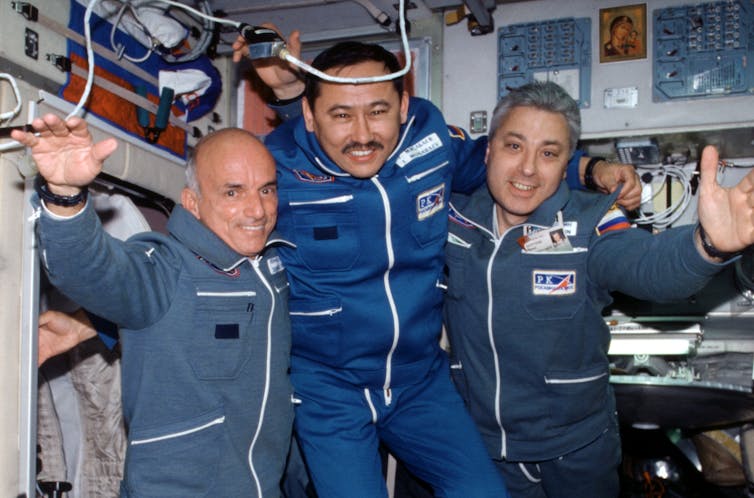 Three men floating in the International Space Station