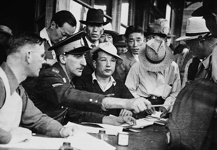 Men sit crowded around table