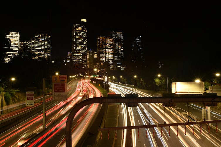 Sydney CBD skyline with headlights on the freeway.