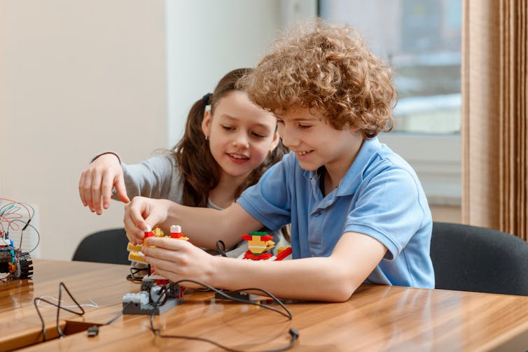 Boy and girl working on making a small robot.