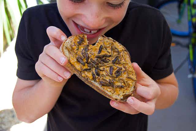 Kid eating peanut butter toast with insects 
