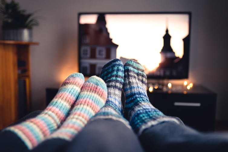 couple's feet in socks in front of a TC screen