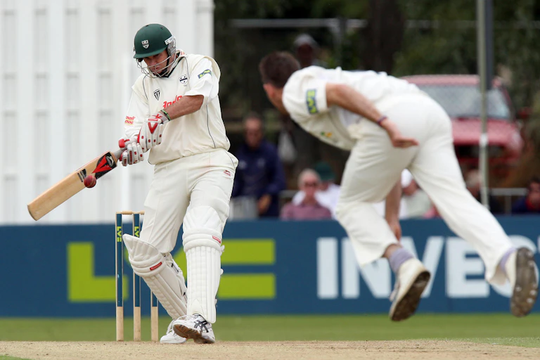 A bowler throws a cricket ball at a batsman.