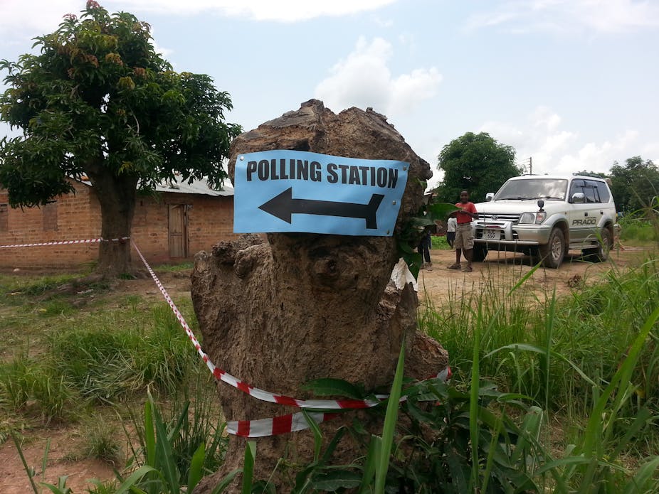 Sign for polling station fixed to a tree stump outside a rural building