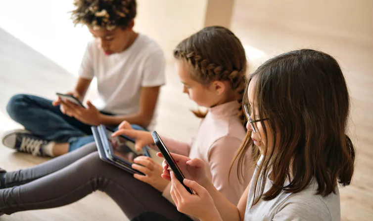 A group of children use digital devices