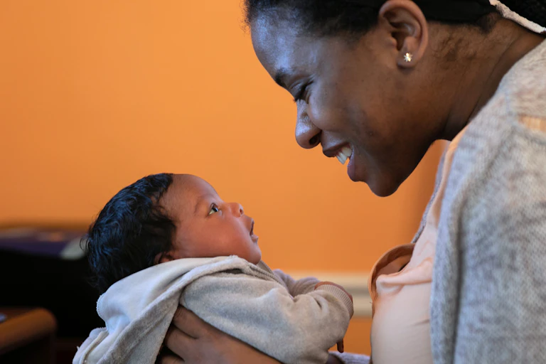 A woman and baby look at each other.