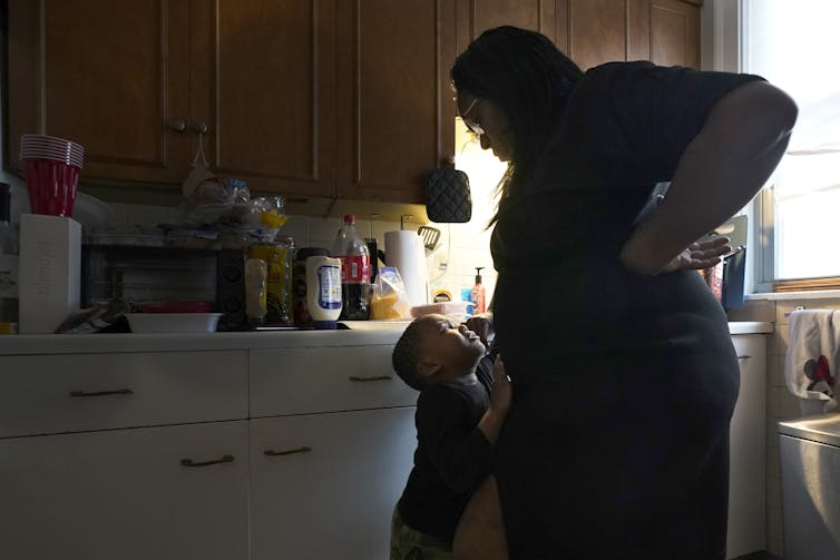 A woman and young boy in a kitchen.