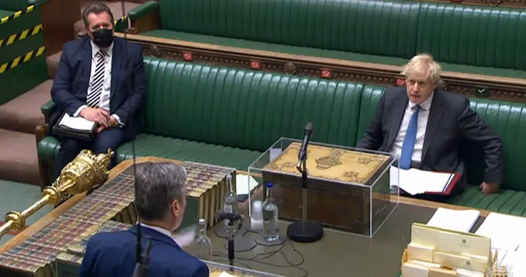 Boris Johnson looking angry at Keir Starmer as they sit opposite each other during prime minister's questions.