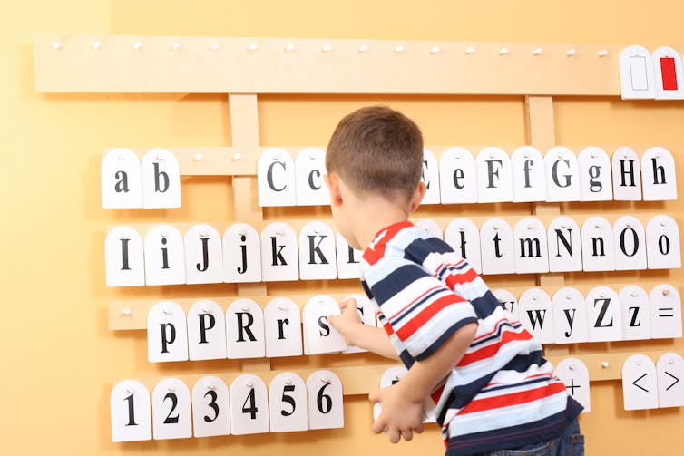 Boy pointing out letters.