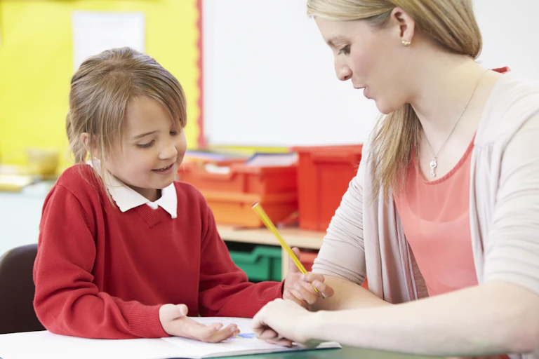 Teaching showing young girl how to write with pencil.