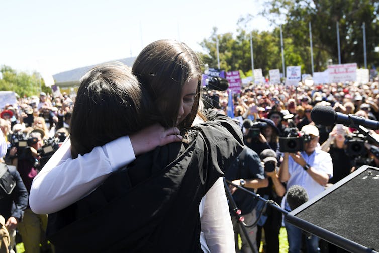 Brittany Higgins hugs an organiser at a protest.