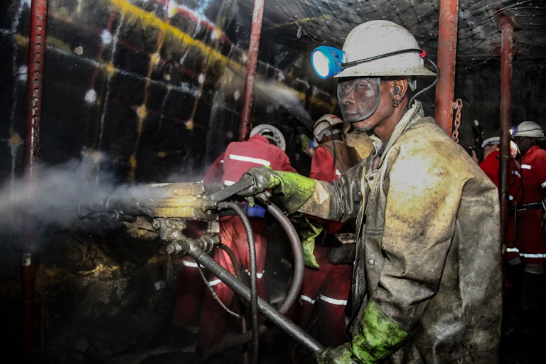 miners drilling holes in rock