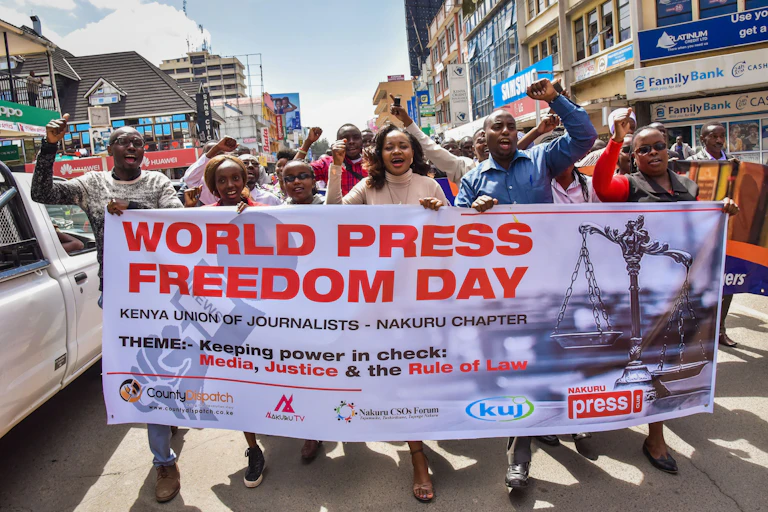A group of men and women holding a banner while marching on the street.