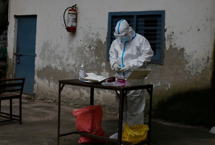 Medic preparing a COVID test at an outside table in New Delhi