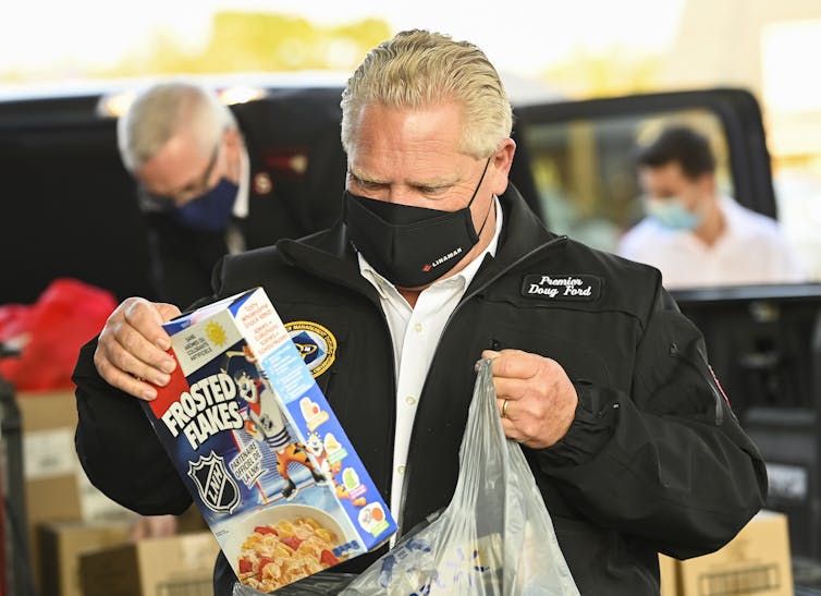 Ontario Doug Ford puts a box of Frosted Flakes into a plastic bag.