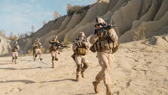 Image of a group of soldiers running through the desert.