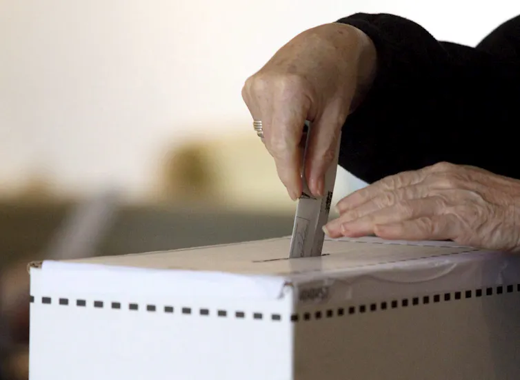 Woman casts vote in ballot box
