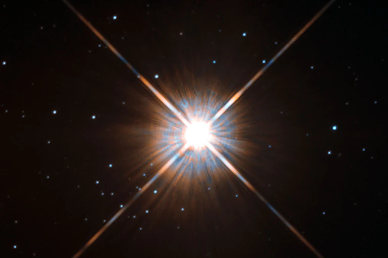 Proxima Centauri shining brightly against the backdrop of black space with small stars.