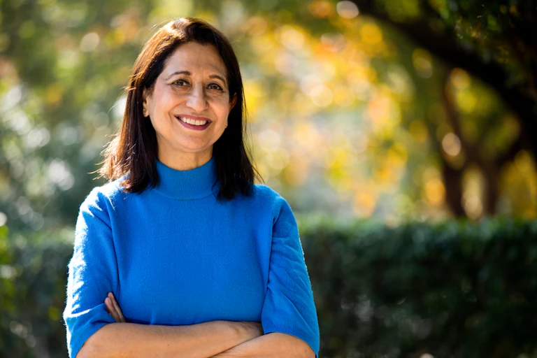 Smiling woman aged around 60 in garden or park